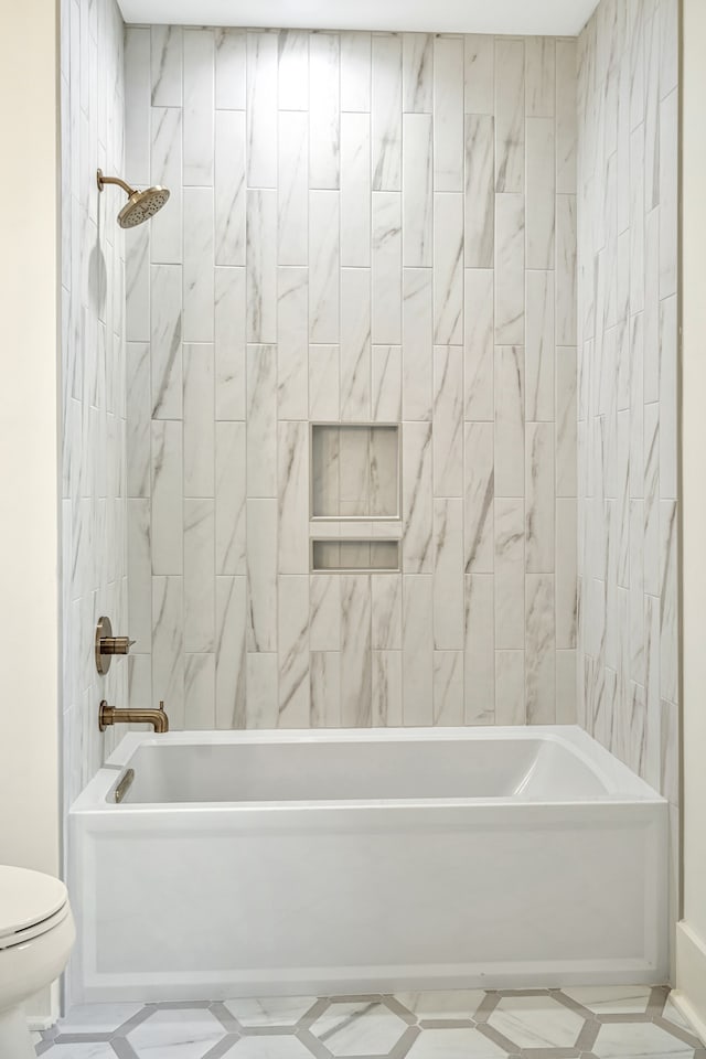 bathroom with tiled shower / bath combo and toilet