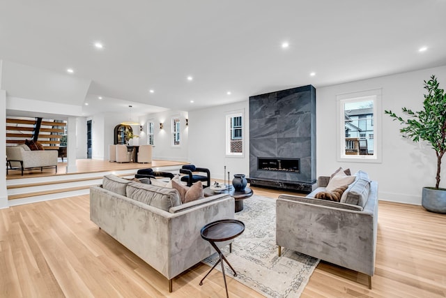 living room featuring a high end fireplace and light hardwood / wood-style floors