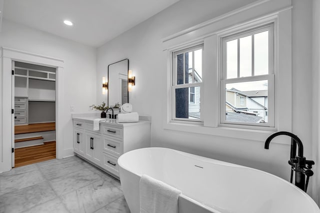 bathroom with vanity, a tub to relax in, and plenty of natural light