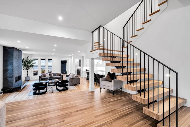 stairway featuring wood-type flooring and a tile fireplace