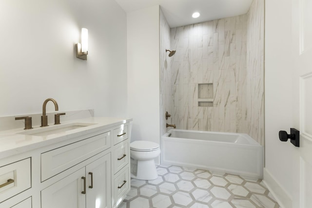 full bathroom featuring tiled shower / bath, vanity, and toilet