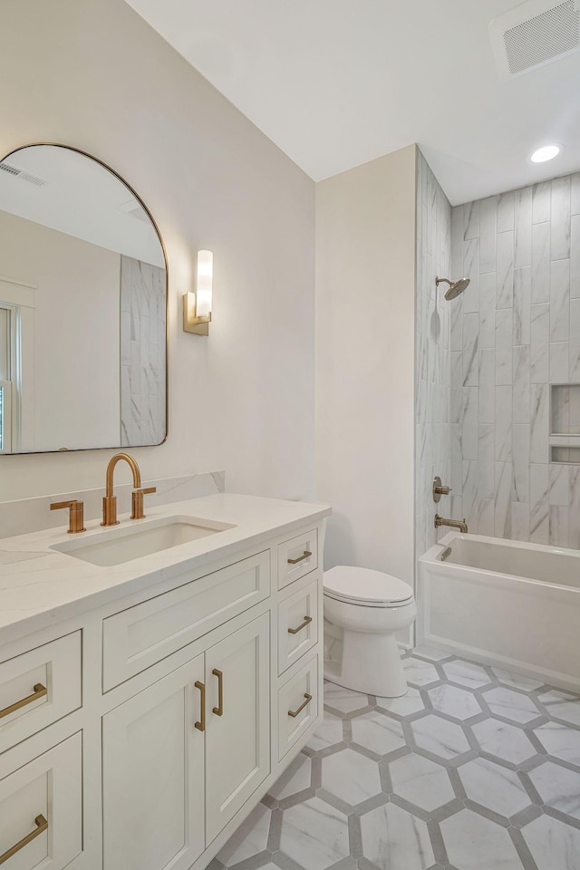 full bathroom with tiled shower / bath combo, vanity, and toilet