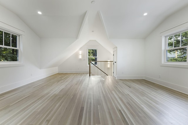 bonus room with lofted ceiling and light hardwood / wood-style flooring