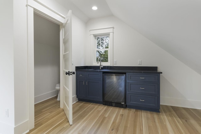 bar with vaulted ceiling, sink, wine cooler, and light wood-type flooring