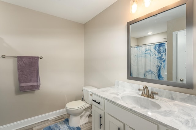 bathroom featuring toilet, vanity, curtained shower, and hardwood / wood-style floors