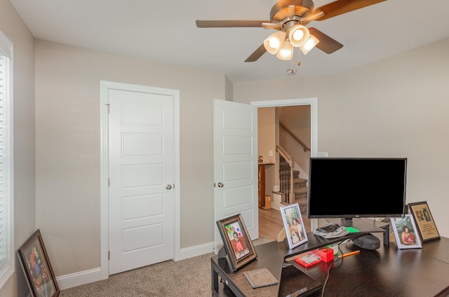 carpeted office space featuring ceiling fan