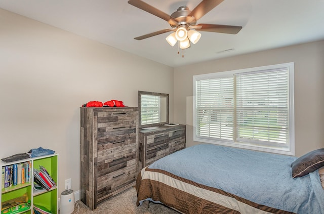 carpeted bedroom featuring ceiling fan and multiple windows