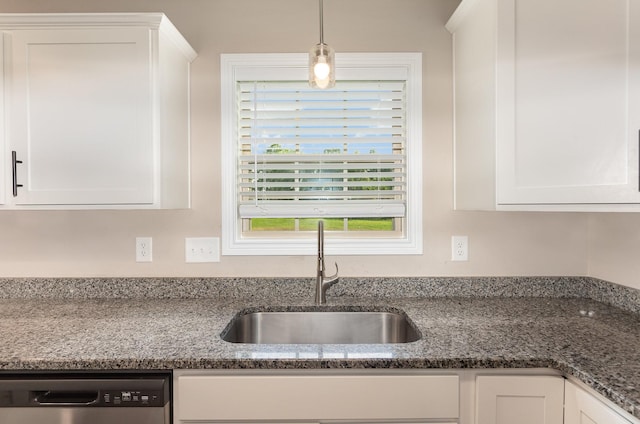 kitchen featuring sink, white cabinets, stainless steel dishwasher, and dark stone countertops