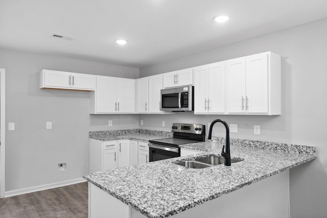 kitchen featuring stainless steel appliances, white cabinetry, dark hardwood / wood-style floors, and sink