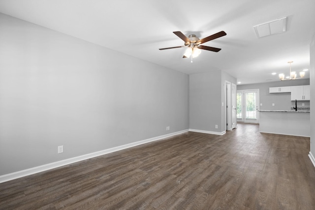 unfurnished living room featuring dark wood-type flooring and ceiling fan with notable chandelier