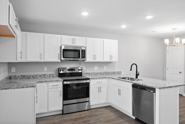 kitchen featuring decorative light fixtures, white cabinetry, kitchen peninsula, and appliances with stainless steel finishes