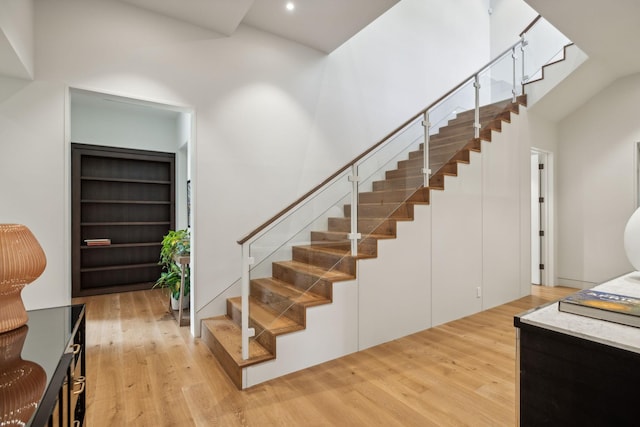 staircase featuring hardwood / wood-style flooring and a high ceiling