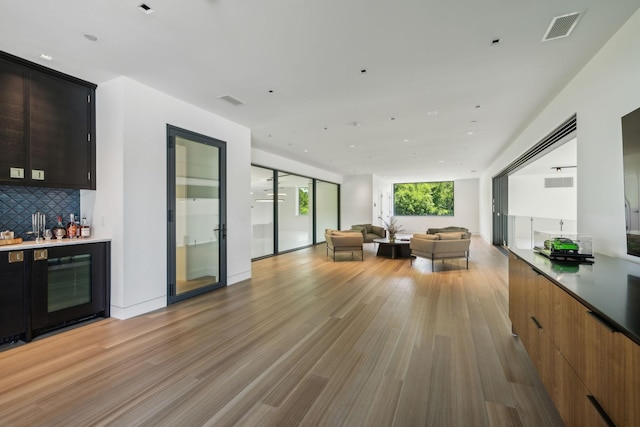 living room with light hardwood / wood-style floors and indoor bar