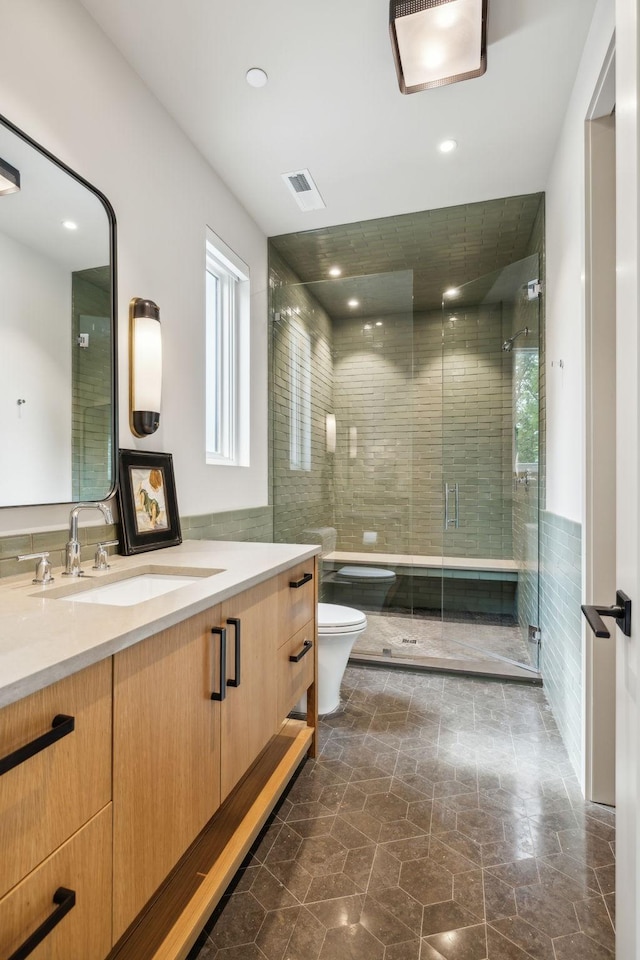 bathroom featuring vanity, tile walls, an enclosed shower, and toilet