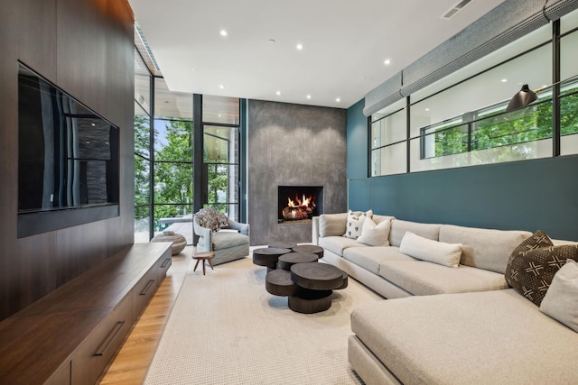 living room with a large fireplace and light hardwood / wood-style floors