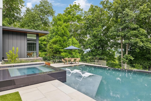 view of swimming pool featuring a patio and an in ground hot tub