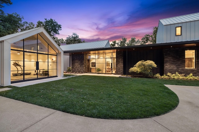 back house at dusk with a yard