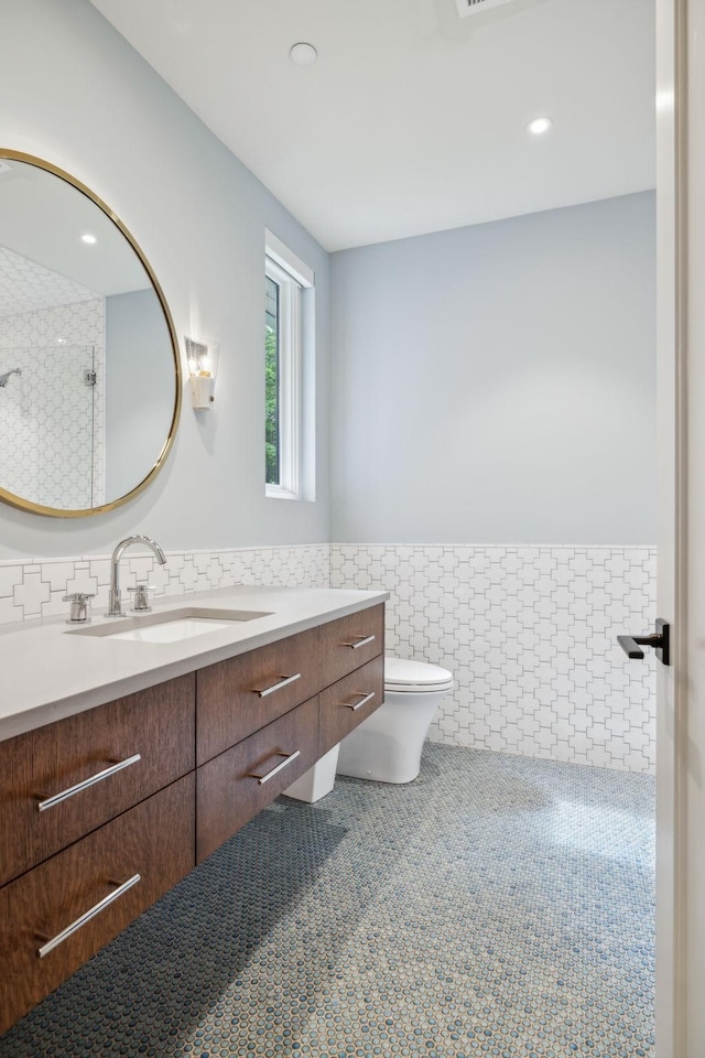 bathroom featuring tile walls, vanity, tile patterned flooring, and toilet