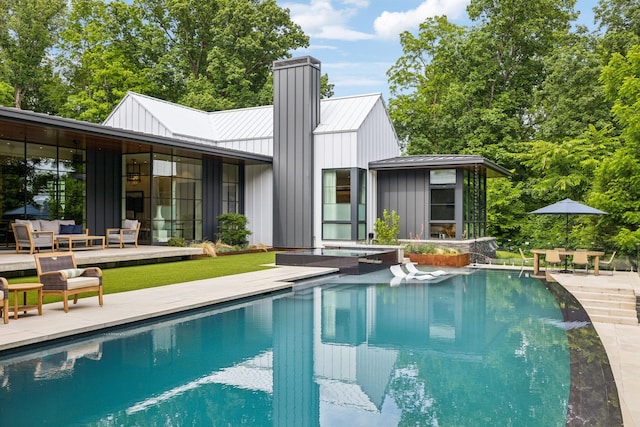 rear view of house with a patio area and outdoor lounge area