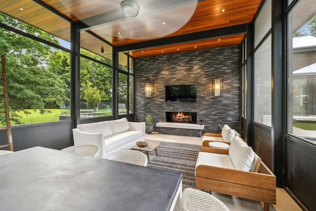 sunroom featuring a fireplace and wooden ceiling