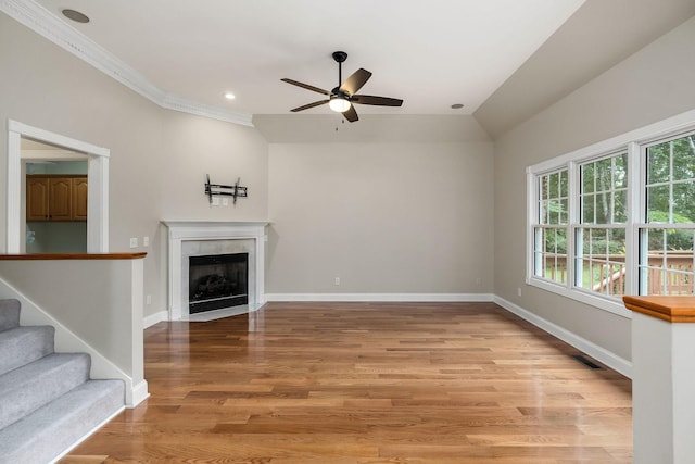 unfurnished living room featuring stairway, ceiling fan, wood finished floors, a tile fireplace, and baseboards