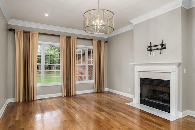 unfurnished living room featuring crown molding, a tiled fireplace, baseboards, and wood finished floors