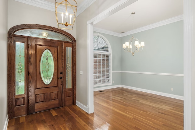 foyer featuring a notable chandelier, dark hardwood / wood-style flooring, and ornamental molding