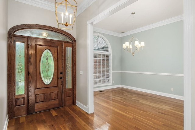 entryway with dark wood finished floors, a notable chandelier, visible vents, ornamental molding, and baseboards