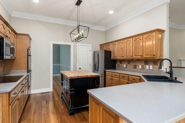 kitchen featuring a center island, dark wood-style flooring, appliances with stainless steel finishes, a sink, and wood counters