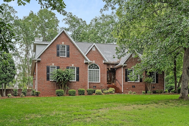 traditional-style home featuring crawl space, brick siding, a chimney, and a front yard