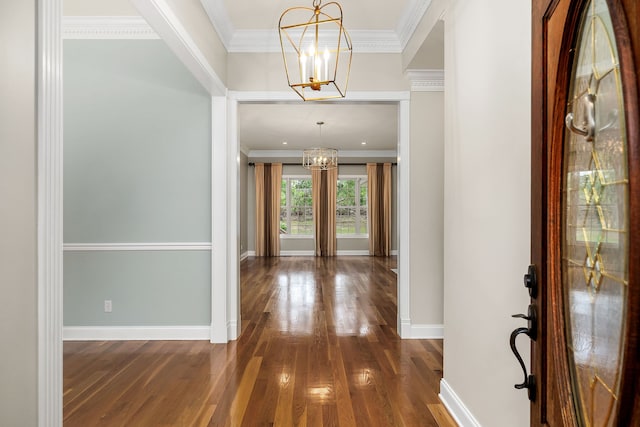 entryway featuring a notable chandelier, ornamental molding, and hardwood / wood-style floors