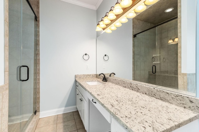 bathroom with vanity, baseboards, ornamental molding, tile patterned floors, and a stall shower