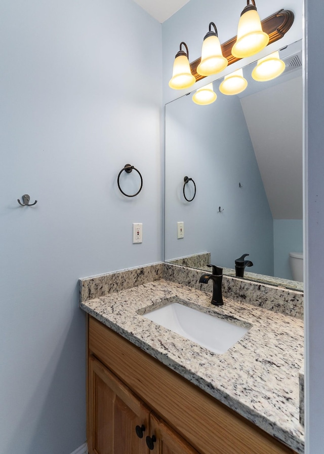 half bath with a chandelier, visible vents, vanity, and toilet