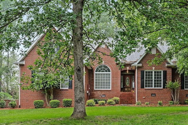 view of front of home featuring crawl space, brick siding, and a front lawn