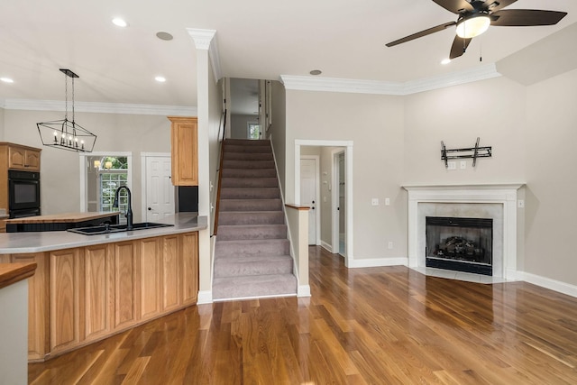 kitchen featuring crown molding, dobule oven black, a sink, and wood finished floors