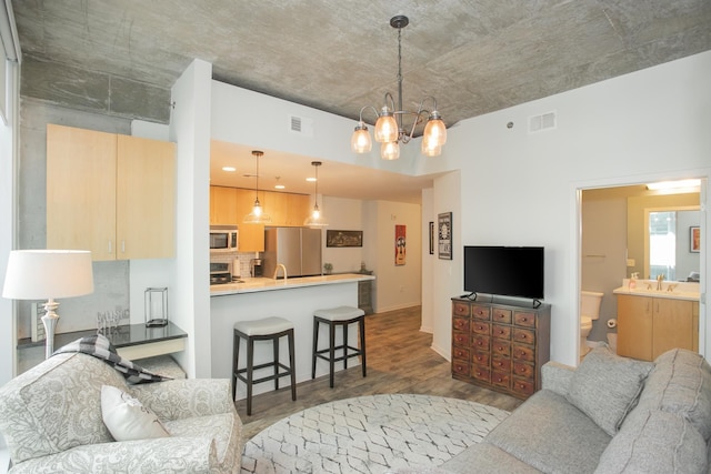 living room with an inviting chandelier, dark wood-type flooring, and sink