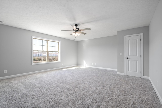 carpeted empty room featuring ceiling fan and a textured ceiling