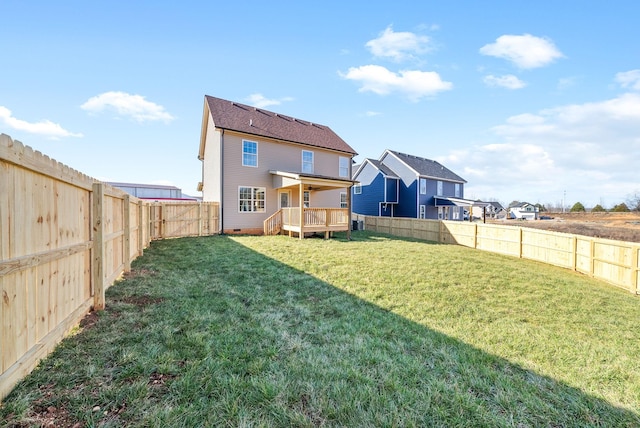 rear view of property featuring a wooden deck and a yard