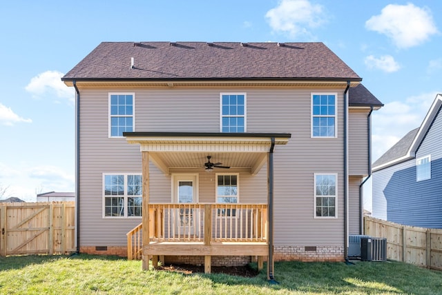 rear view of house featuring ceiling fan, a deck, and a yard