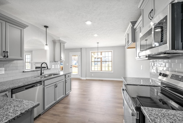 kitchen featuring backsplash, pendant lighting, sink, and stainless steel appliances