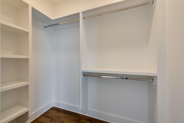 walk in closet with dark wood-type flooring