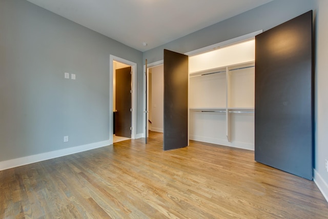 unfurnished bedroom with light hardwood / wood-style flooring and a closet