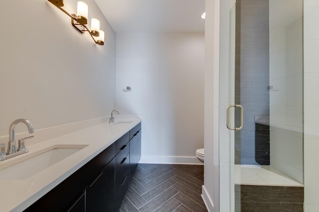 bathroom featuring vanity, toilet, and a shower with door