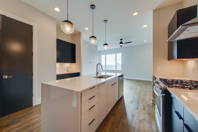 kitchen featuring dark hardwood / wood-style flooring, stainless steel appliances, a kitchen island with sink, sink, and white cabinets