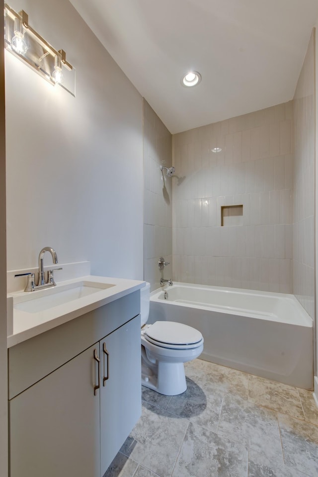 full bathroom featuring tiled shower / bath, vanity, and toilet