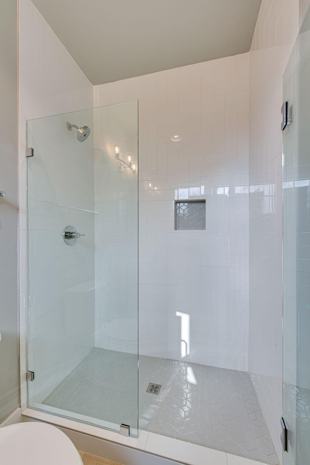 bathroom featuring an enclosed shower and toilet