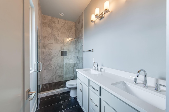 bathroom featuring tile patterned flooring, vanity, a shower with door, and toilet