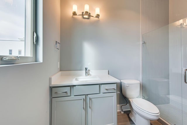 bathroom with walk in shower, vanity, and toilet