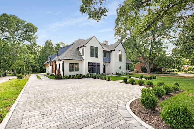 french country inspired facade with a front lawn