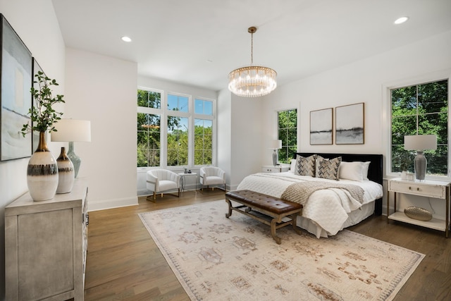 bedroom with a chandelier and dark hardwood / wood-style floors